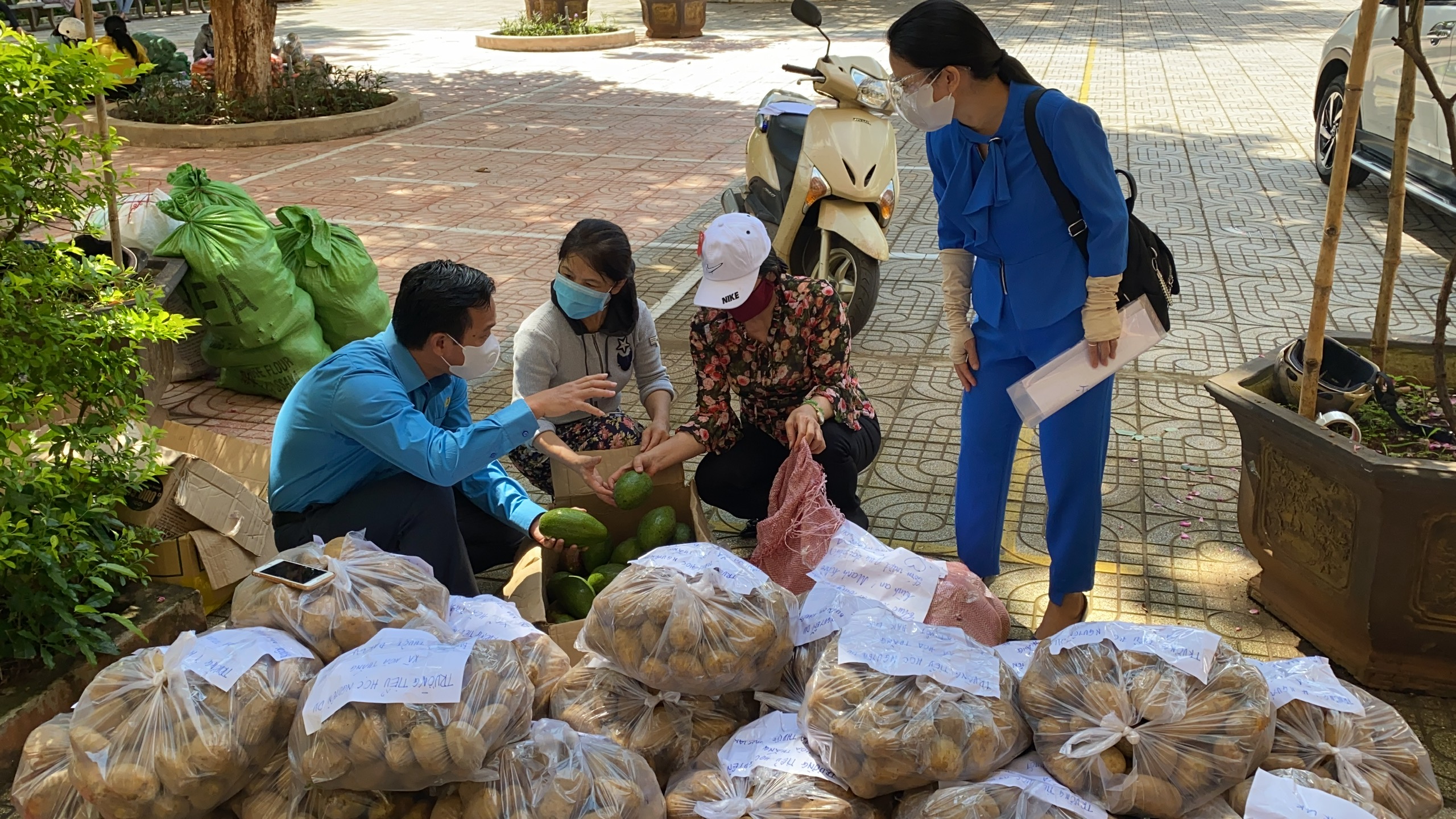 Ông Lưu Tiến Quang (ngoài cùng bên trái), Chủ tịch Công đoàn ngành GD tỉnh trao đổi với giáo viên về cách phân loại rau, củ, quả trước khi chất lên xe chuyển vào phía Nam.